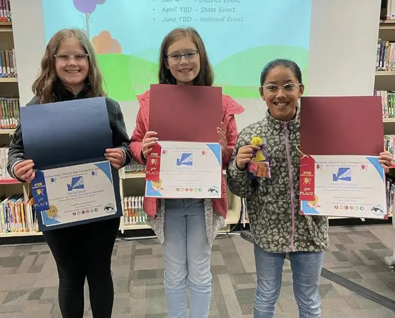 three girls holding up their awards